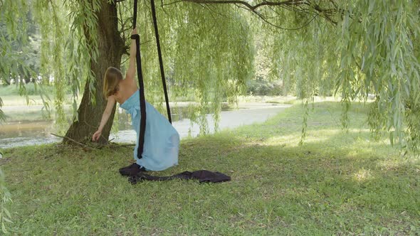 View of a Girl in Blue Dress That Holds Aerial Silk