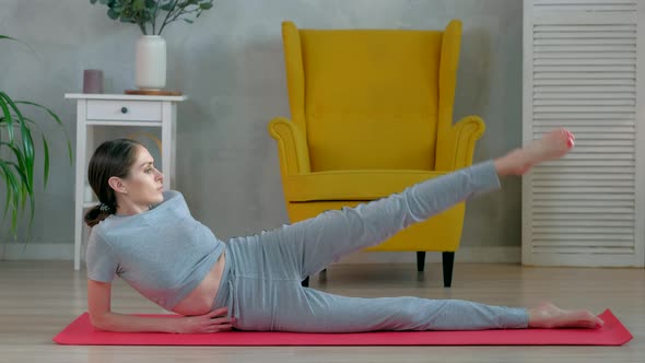 Brunette Female does yoga exercises in the morning at home.