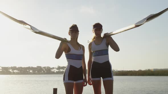 Portrait of two female rowers by a river