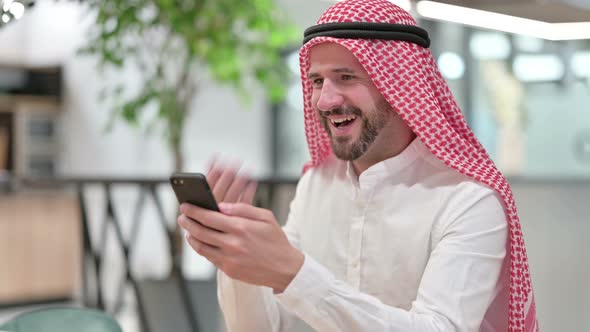 Cheerful Arab Businessman Talking on Smartphone 