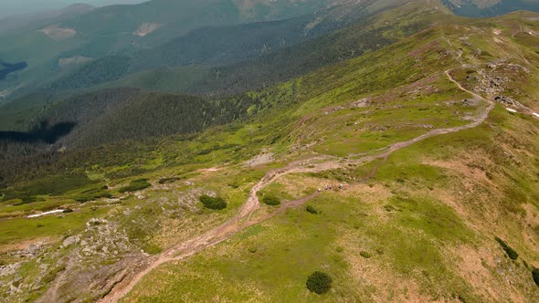 Four Hikers Walk on Top of a Mountain with Backpacks on Their Shoulders