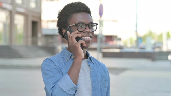 Portrait of Young African Man Talking on Phone Outdoor