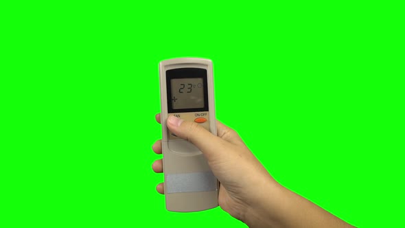 Hand Pushing Temperature Button on Air Conditioner Remote Control. Green Screen