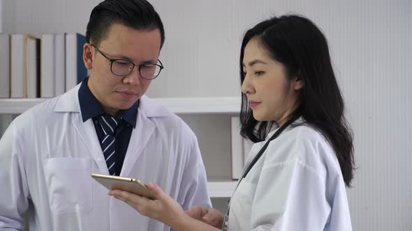 Doctors using tablet, discussing serious case