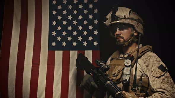 A Soldier Stands Near the US Flag