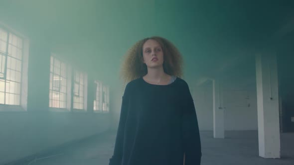 Fashionable young woman in an abandoned warehouse