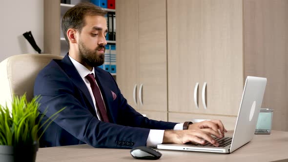 Young Attractive Entrepreneur in His Office Working on the Computer