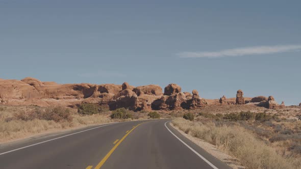 Driving On Empty Road Through Amazing Arches National Park In Usa On Sunny Day