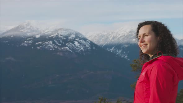 Adventurous Girl Hiking in the Mountains During a Sunny Winter Sunset