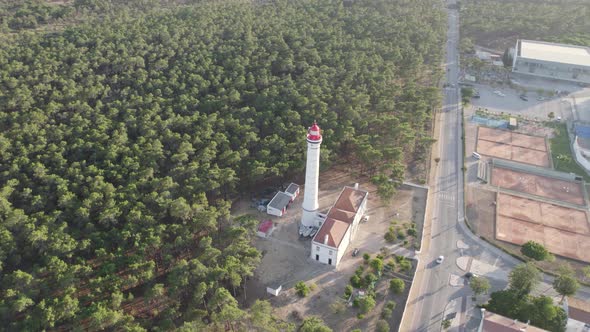 Topdown orbiting shot Lighthouse surrounded by forest and stadium, Vila Real de Santo Antonio