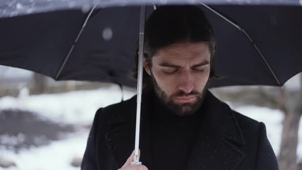 Sad Man Under Umbrella at the Funeral