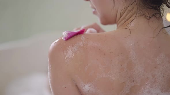 Closeup Shoulder of Slim Young Unrecognizable Caucasian Woman Washing Skin with Flower Petal in Slow