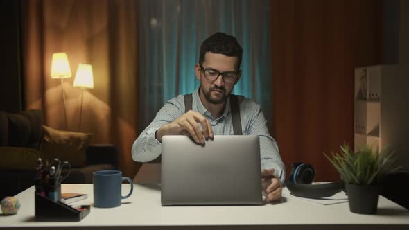 Man Sitting at Desk She Opens Her Laptop and Starts Her Work