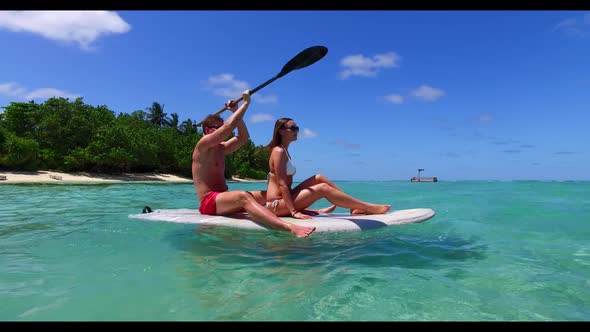 Boy and girl tan on tropical resort beach trip by shallow ocean and white sandy background of the Ma