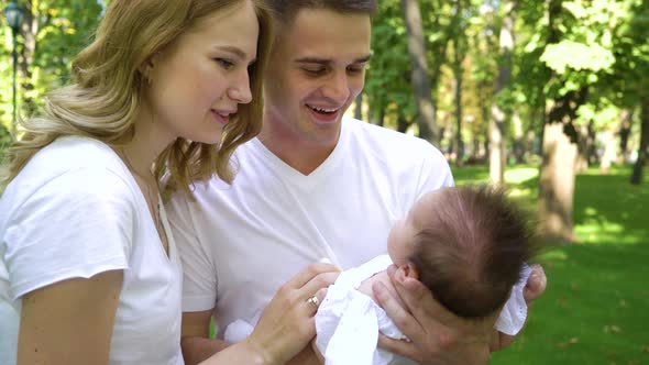 Adorable Young Family with Little Baby Girl Spending Leisure in Park