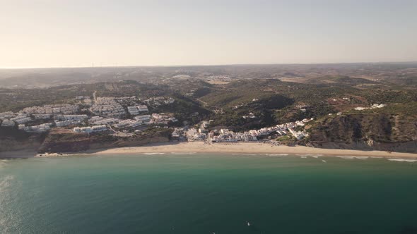 Dolly in aerial view of a small beach Praia da Salema Algarve Portugal.