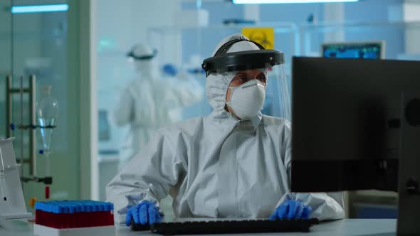 Laboratory Technician Assistant in Ppe Suit Analyzing Blood Sample