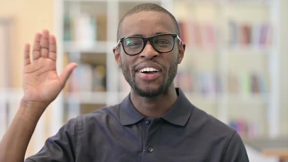 Portrait of Cheerful Young African Man Waving Hello