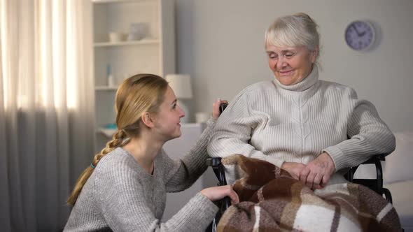 Granddaughter Covering Handicapped Granny With Blanket, Taking Care and Support