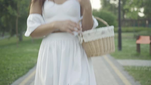 Camera Moves Up Along Slim Charming Middle Eastern Woman White Dress Straw Hat Strolling Outdoors