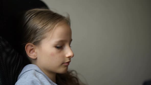 Little Sad Girl is Sitting on Black Office Chair Punishment Serious Face