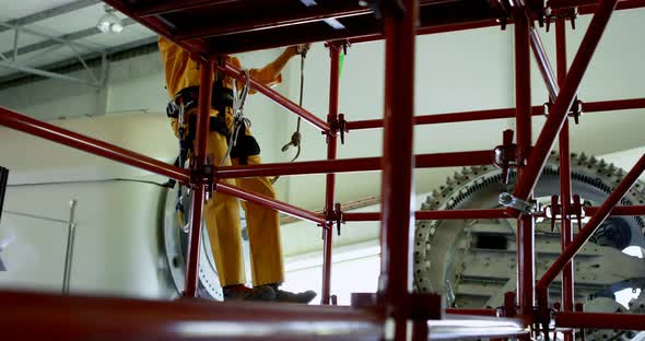 Male worker moving down from scaffolding at solar station 4k