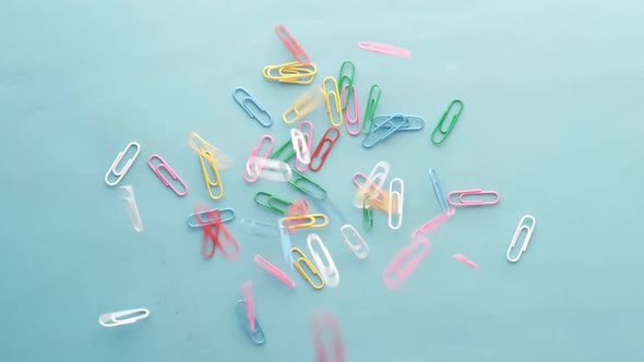 Slow Motion of Paper Clips Drop on Blue Background