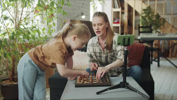 The Girl and Her Mother Put the Pieces on the Chessboard and Prepare for the Stream