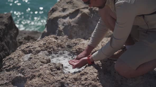 Male Geologist Examines Samples of Crystals Sea Salt From the Rocks Near Sea