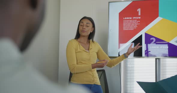 Diverse male and female business colleagues discussing at meeting in office