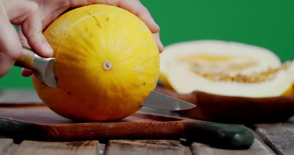 Male Hand with a Knife Cut a Whole Melon Piece.