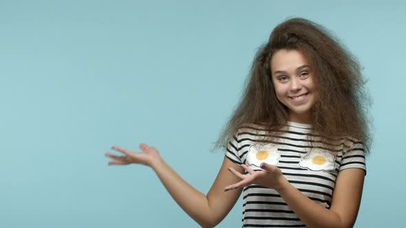 Beautiful Glamour Girl with Thick Long Hair Demonstrate Product on Copy Space Pointing Hands Left