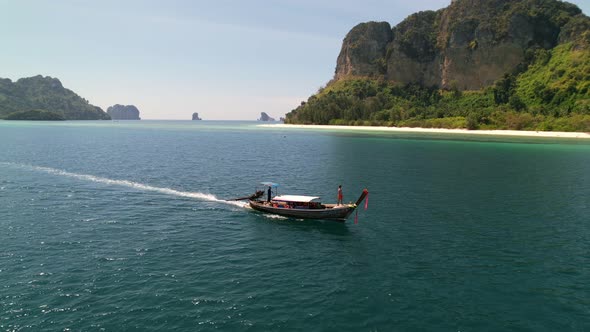 aerial drone tracking a tourist on a thai longtail boat motoring through the many islands of the and