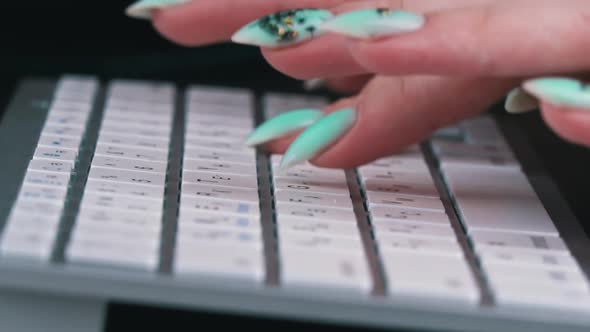 Business Woman's Fingers are Typing on the Keyboard of a White Laptop