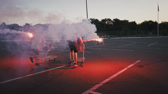 Young Friends Racing on Shopping Carts at Deserted Parking Lot of Mall