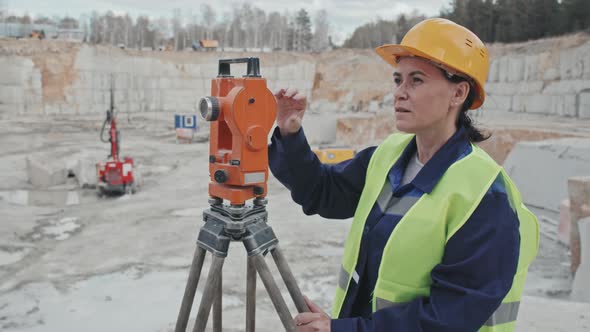 Female Worker Using Measuring Equipment in Granite Quarry