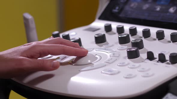 Hand of Doctor on Panel of Ultrasound Machine