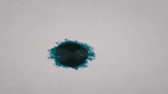 Drop of Blue Ink Falls on White Paper in Macro