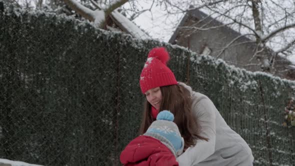 Slomo Authentic Cute Young Woman Mom in Red Hat Holding Spinning Little Happy Smiling Cute Son