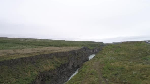 Aerial flight over a glacial mountain river in Iceland