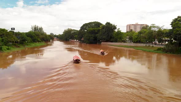 Aerial view of two Thai river boats passing each other on the Ping River in Chiang Mai Thailand.