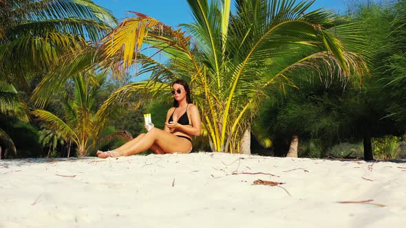 Young smiling ladies relaxing having fun on the beach on paradise white sand and blue 4K background