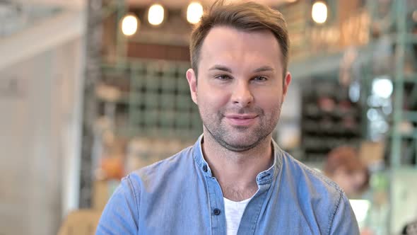 Portrait of Casual Man with Laptop Pointing and Inviting