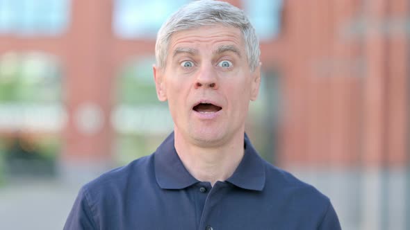 Outdoor Portrait of Middle Aged Man Shaking Head As Yes Sign