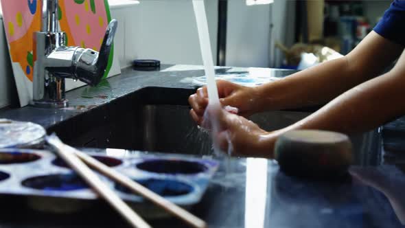 Schoolboy washing his hand after drawing class