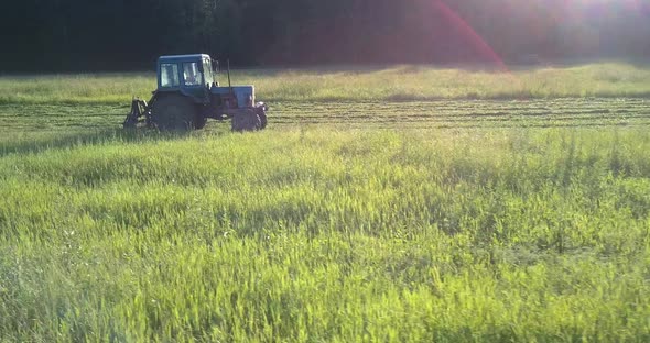 Machine with Mower Drives Fast Along Large Green Field