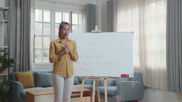 Asian Female Teacher With Marker Pen Teaching Math At Home