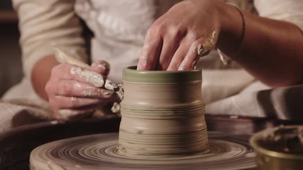 Pottery Workshop  Female Hands Making the Ribs on the Pot Shape Using a Tool