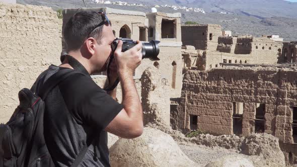 Caucasian Male Tourist Taking Photos of Abandoned Old Ruined Village of Al Hamra Near Nizwa, Oman