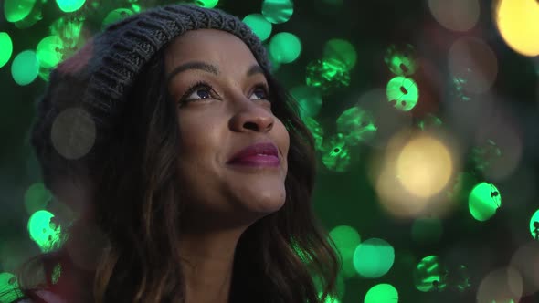 Close view of woman looking around surrounded in green lights